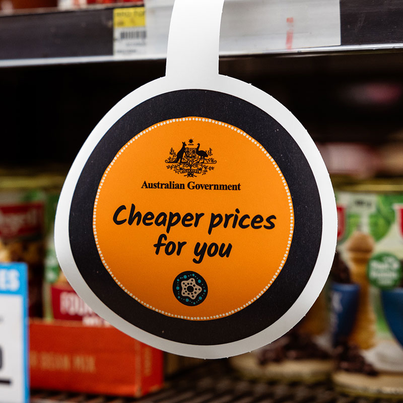 A store sign wobbler with the Commonwealth Coat of Arms logo and cheaper prices for you printed on it