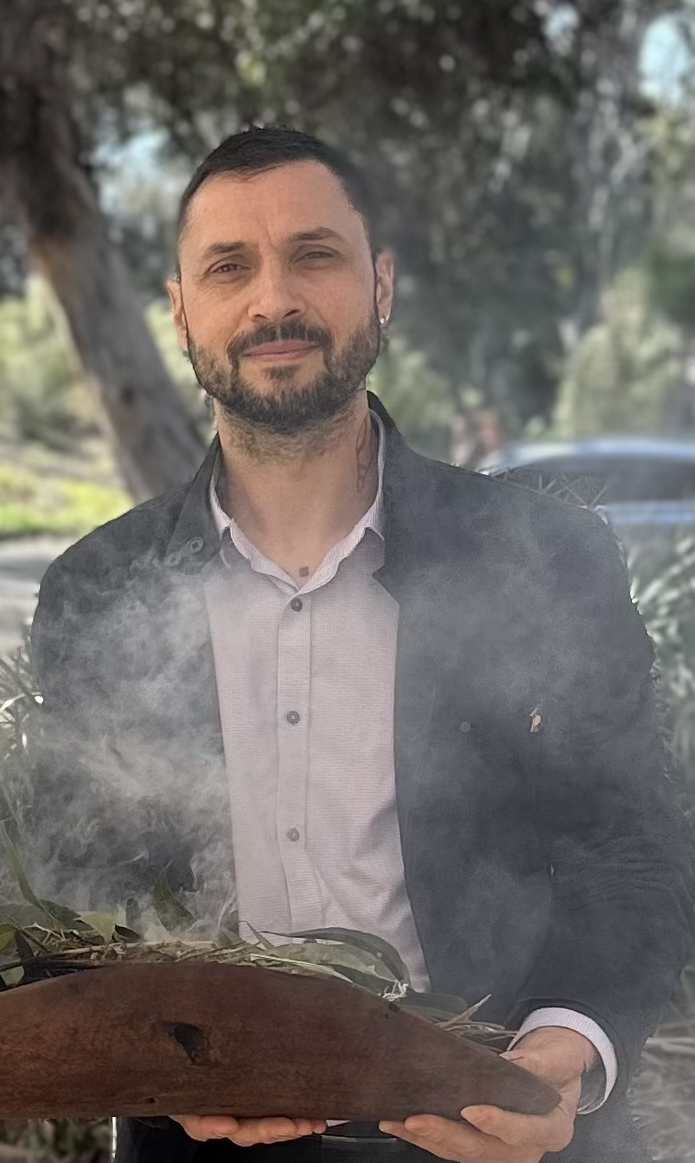A man stands in front of smoke during ceremony