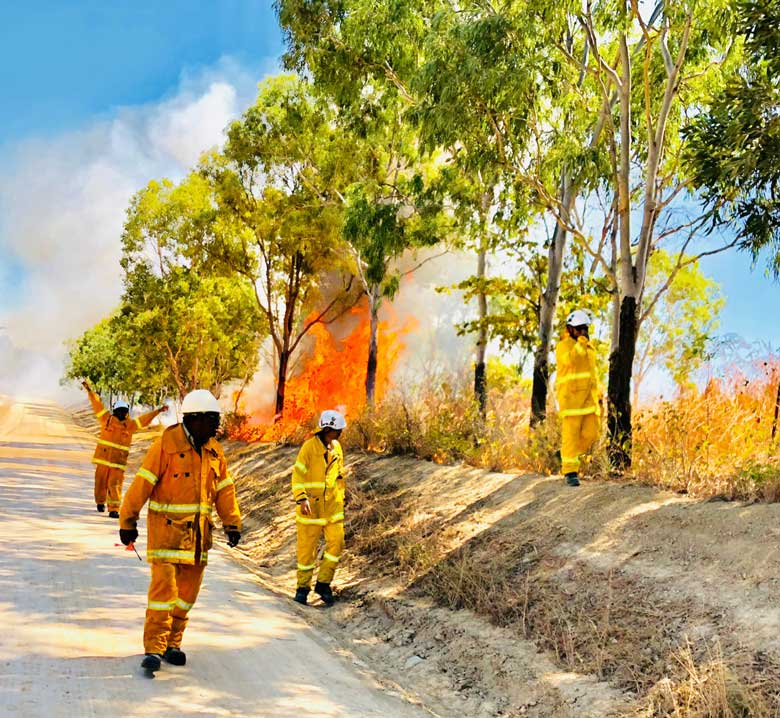 Yuku Baja Muliku Land and Sea Rangers undertaking cultural burning on country dirt road