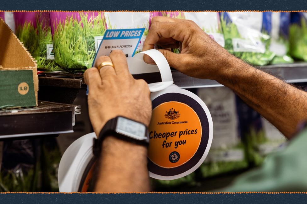 Hands putting a Cheaper prices for you wobbly sign on a store shelf