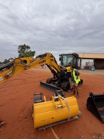 James Torres and Karl Walter (Works Manager) inspecting new excavator.  A major focus this year will be training RJED employees in various skills including plant operation.